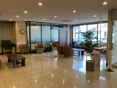 a lobby with a waiting area with chairs and tables at Smile Hotel Tokyo Shinkoiwa in Tokyo