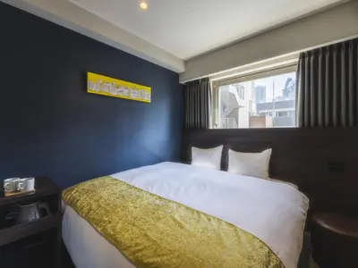 a bedroom with a large bed with a window at KOKO HOTEL Ikebukuro East - formerly Hotel Wing International Ikebukuro in Tokyo