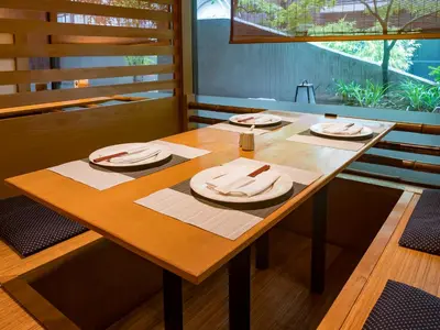 a wooden table with plates and napkins on it at Shibuya Creston Hotel in Tokyo