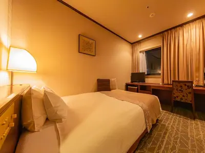 a hotel room with a bed and a desk at Shibuya Creston Hotel in Tokyo