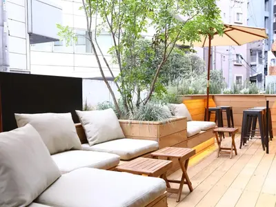 a seating area with couches and tables on a patio at KOKO HOTEL Korakuen - formerly Hotel Wing International Korakuen in Tokyo