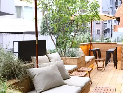 a patio with white couches and tables and trees at KOKO HOTEL Korakuen - formerly Hotel Wing International Korakuen in Tokyo
