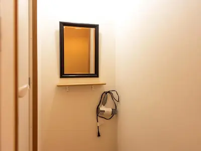 a mirror on a wall next to a door at Sakura Ryokan Asakusa Iriya in Tokyo