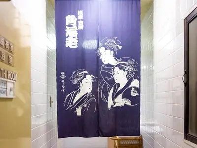 a shower curtain with three women on it in a bathroom at Sakura Ryokan Asakusa Iriya in Tokyo
