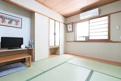 a living room with a television and a window at Sakura Ryokan Asakusa Iriya in Tokyo