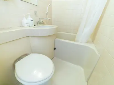 a white bathroom with a toilet and a sink at Sakura Ryokan Asakusa Iriya in Tokyo