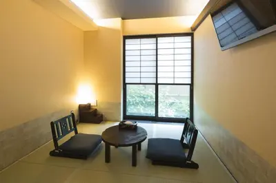 a room with two chairs and a table and a window at Guest House Wagokoro in Tokyo