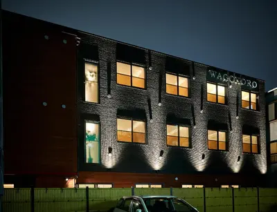 a building with lit windows on the side of it at Guest House Wagokoro in Tokyo