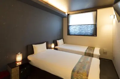 a hotel room with two beds and a window at Guest House Wagokoro in Tokyo