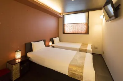 a small room with two beds and a window at Guest House Wagokoro in Tokyo