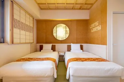two beds in a small room with a window at HOTEL MYSTAYS Asakusabashi in Tokyo