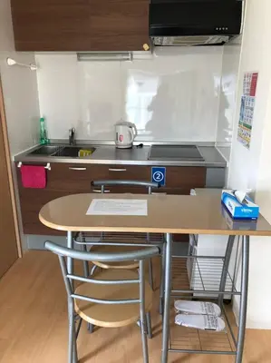 a small kitchen with a table and a sink at Issyuku hostel in Tokyo