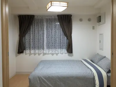 a bedroom with a bed and a window at Issyuku hostel in Tokyo