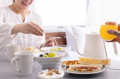 a woman sitting at a table with a plate of food at Tokyu Stay Ikebukuro in Tokyo