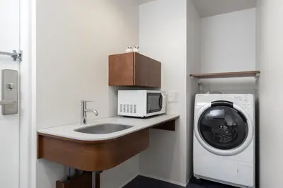 a small kitchen with a sink and a washing machine at Tokyu Stay Ikebukuro in Tokyo