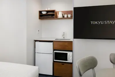 a small kitchen with a sink and a microwave at Tokyu Stay Ikebukuro in Tokyo