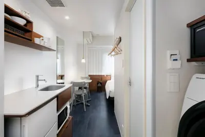 a kitchen with a sink and a room with a bed at Tokyu Stay Ikebukuro in Tokyo