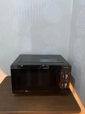 a microwave oven sitting on top of a wooden table at Oyado Cocochi in Tokyo