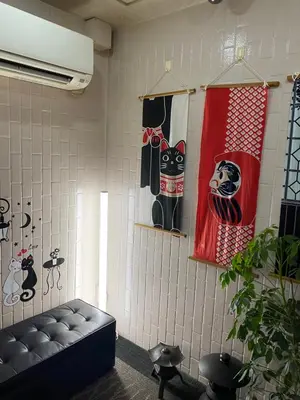 a room with a couch and a cat on the wall at Oyado Cocochi in Tokyo