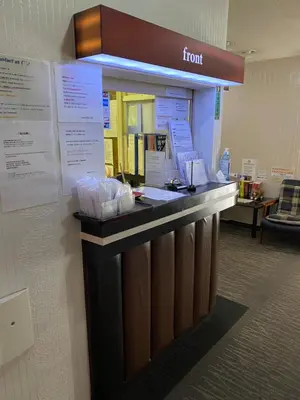 a front counter in a waiting room with signs at Oyado Cocochi in Tokyo