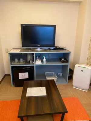 a living room with a tv and a coffee table at Oyado Cocochi in Tokyo