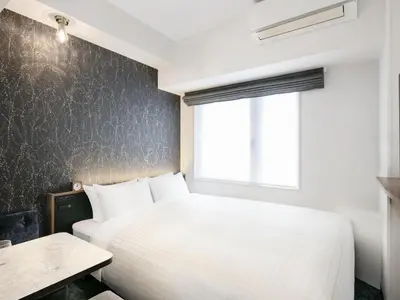 a bedroom with a white bed and a window at Tokyu Stay Nishi Shinjuku in Tokyo