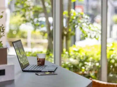 a laptop computer sitting on a table with a cup of coffee at Tokyu Stay Nishi Shinjuku in Tokyo