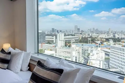 a bedroom with a large window with a city view at Tokyu Stay Aoyama Premier in Tokyo