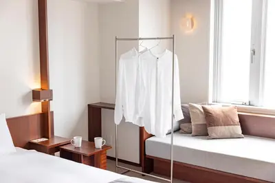 a bedroom with a white shirt hanging on a rack at Tokyu Stay Aoyama Premier in Tokyo