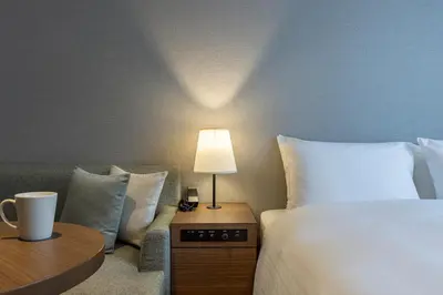 a hotel room with a bed and a table with a lamp at Tokyu Stay Aoyama Premier in Tokyo