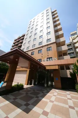a tall building with a parking lot in front of it at Urbain Tokyo Haneda Kamata in Tokyo