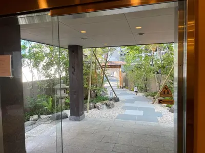 a glass door leading into a garden with a swing at Hotel Fukudaya in Tokyo