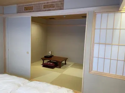 a room with a bed and a table with a window at Hotel Fukudaya in Tokyo