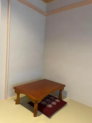 a wooden table in a corner of a room at Hotel Fukudaya in Tokyo