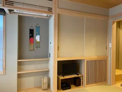 a room with wooden shelves and a tv at Hotel Fukudaya in Tokyo