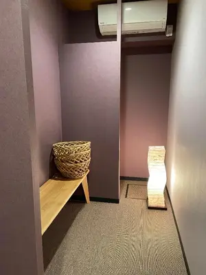 a room with a bench and a basket on a wall at Hotel Fukudaya in Tokyo