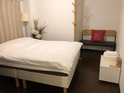a bedroom with a white bed with a red pillow at Ogi-Ohashi Apartment in Tokyo