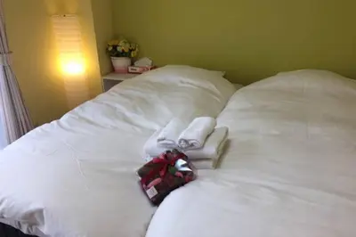 a white bed with two towels on top of it at Ogi-Ohashi Apartment in Tokyo