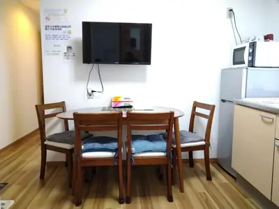 a small kitchen with a table and chairs and a refrigerator at Rimon Apartment in Tokyo