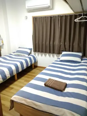 two beds in a room with blue and white stripes at Rimon Apartment in Tokyo