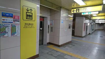 a hallway of a subway station with a sign on the wall at Rimon Apartment in Tokyo