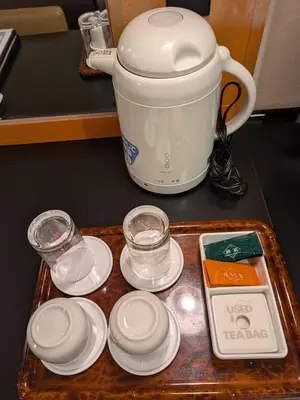 a coffee pot on a tray with plates and glasses at Hotel Listel Shinjuku in Tokyo