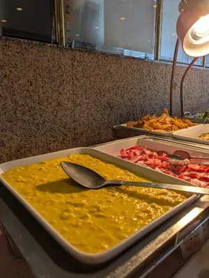 a counter with two trays of food with a spoon at Hotel Listel Shinjuku in Tokyo