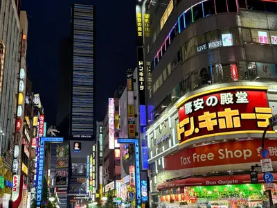 a busy city street at night with neon signs at Hotel Listel Shinjuku in Tokyo