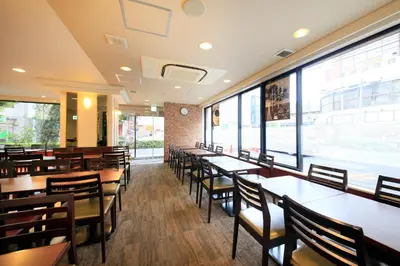 a dining room with tables and chairs and windows at Smile Hotel Tokyo Ayase Ekimae in Tokyo