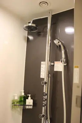 a shower in a bathroom with a mirror at Hotel Ryumeikan Tokyo in Tokyo