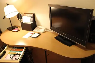 a desk with a computer monitor and a phone on it at Hotel Ryumeikan Tokyo in Tokyo