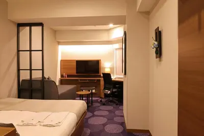 a hotel room with a bed and a desk at Hotel Ryumeikan Tokyo in Tokyo