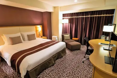 a hotel room with a large bed and a desk at Hotel Ryumeikan Tokyo in Tokyo