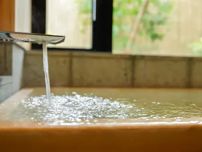 a stream of water pouring from a faucet in a sink at Kaminarimon Ryokan in Tokyo